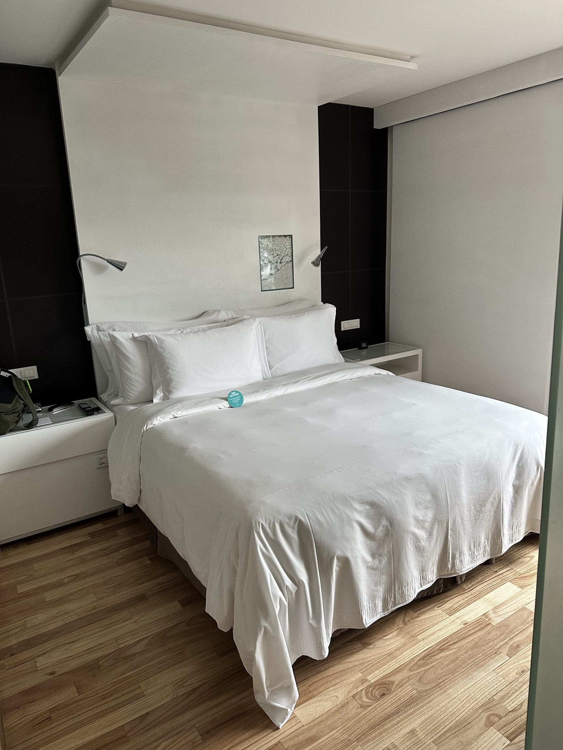 Hotel Unique São Paulo guest room with a white bed and wooden floor.