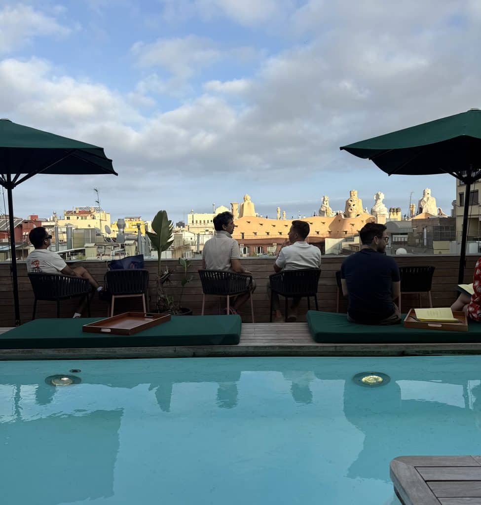 Sir Victor’s rooftop pool, terrace umbrellas and Barcelona buildings in the late-day light.