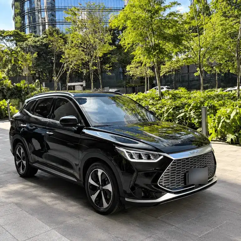 F1 luxury vacation package Black SUV outside W São Paulo, surrounded by trees and glass buildings, with its license plate blurred.