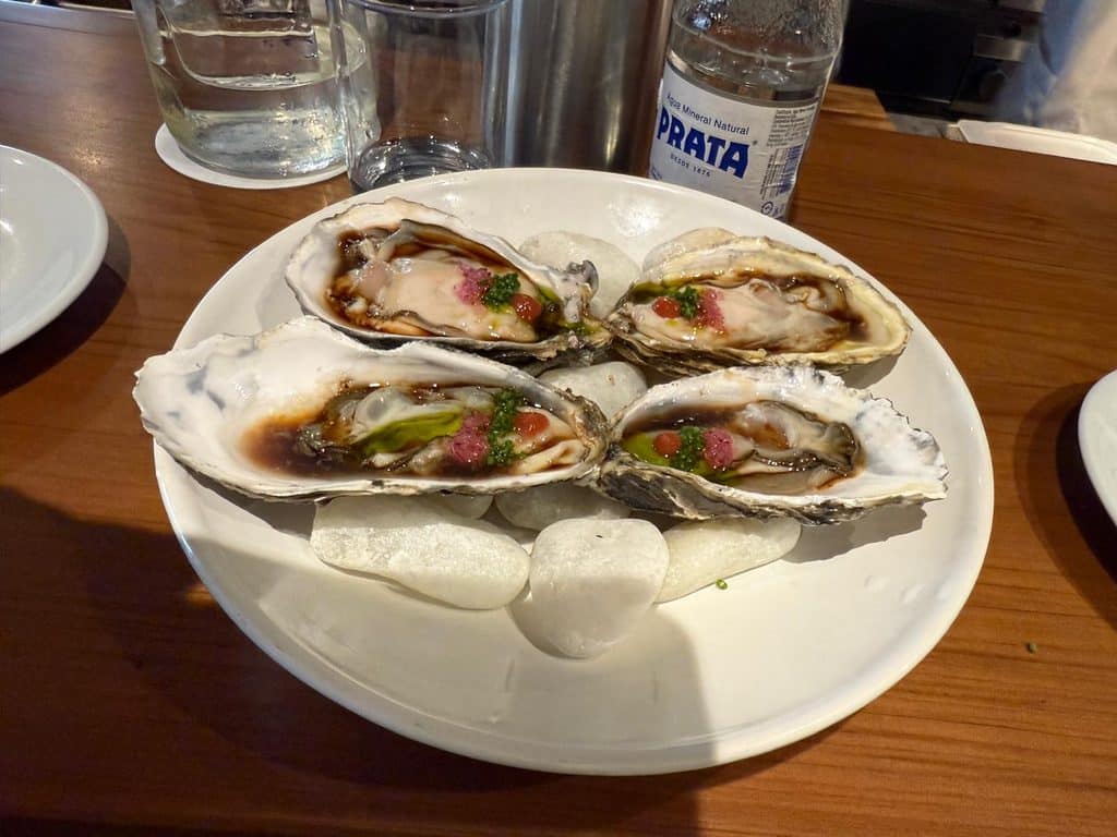 São Paulo Luxury Travel Four oysters with colorful garnishes served at the bar at Tan Tan in São Paulo
