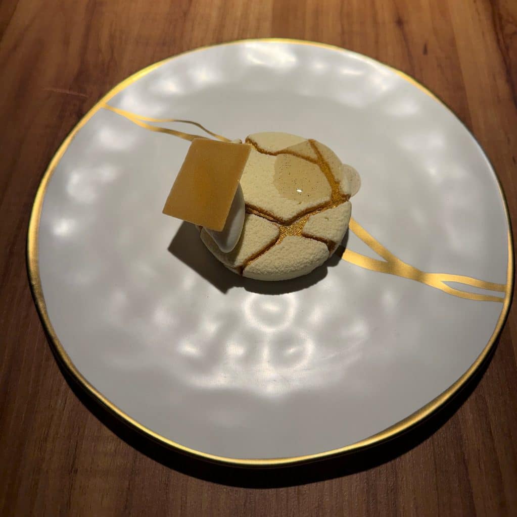 Luxury Formula 1 Travel A small tasting-menu dish on a white plate with gold decoration at Evvai in São Paulo.