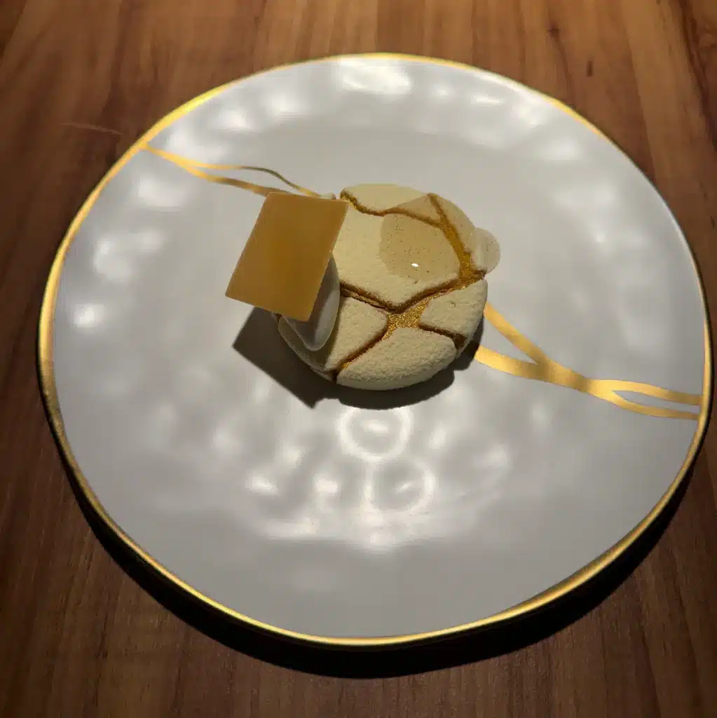 F1 luxury vacation package  A small tasting-menu dish on a white plate with gold decoration at Evvai in São Paulo.