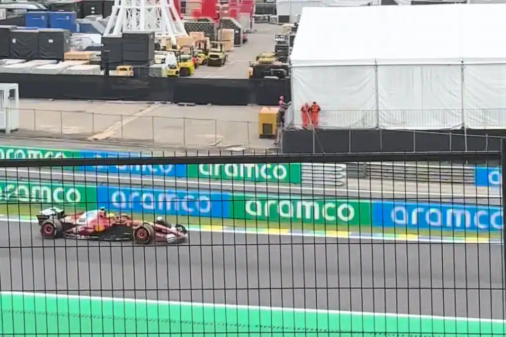  A red Ferrari Formula 1 car passes behind the safety fence at Interlagos.