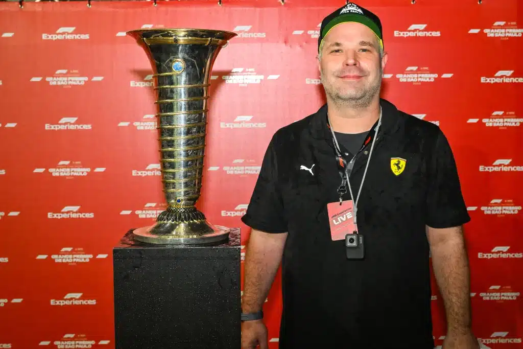  Richard Jarocki wears a Ferrari polo beside the championship trophy at an F1 Experiences photo opportunity.
