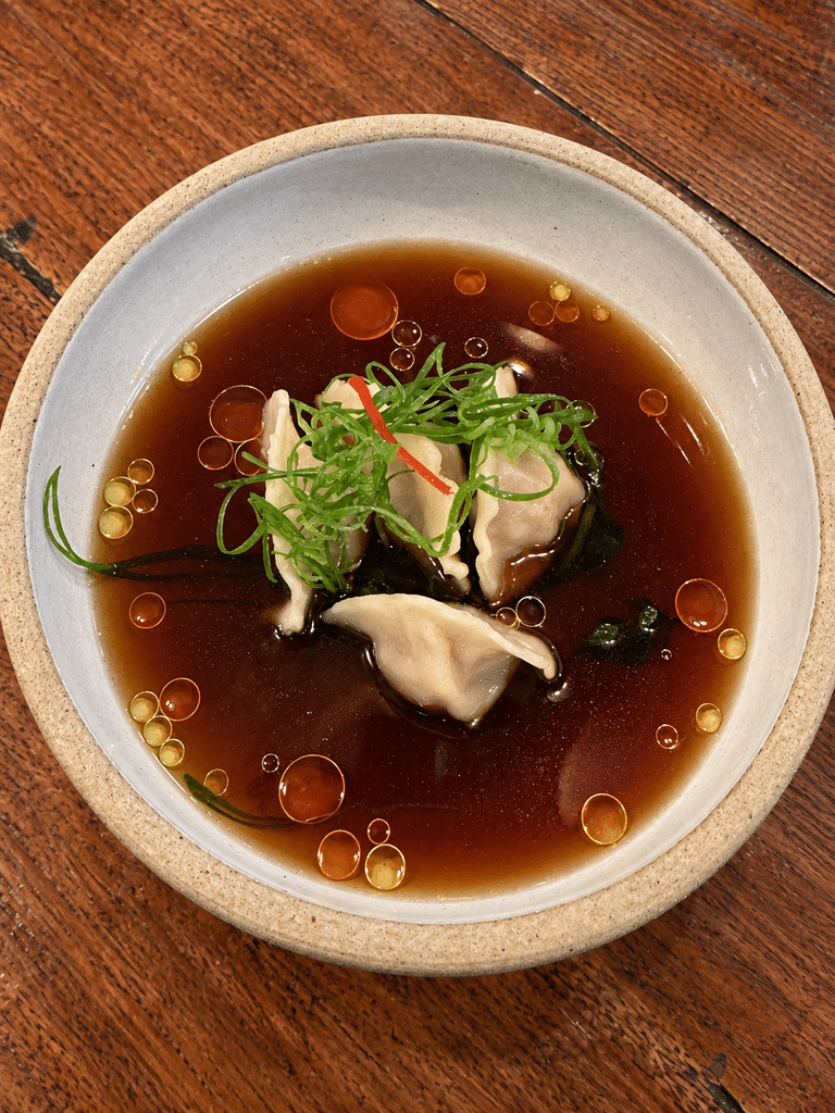 A Casa do Porco review: Dumplings in dark broth with herbs and droplets of oil at A Casa do Porco.