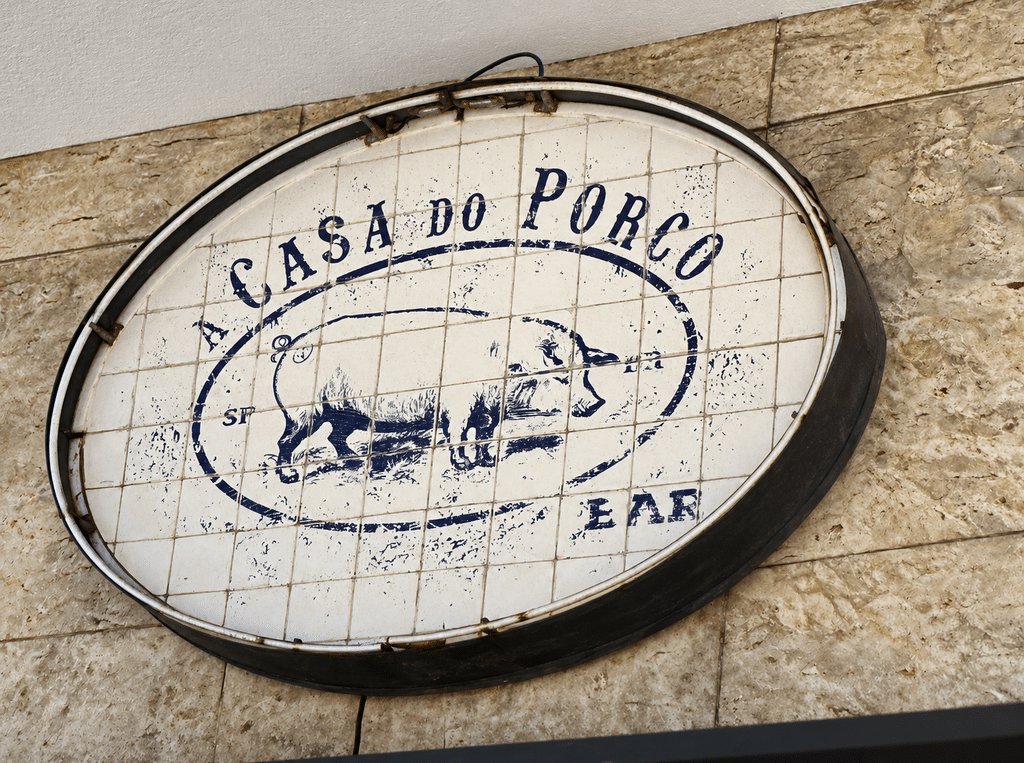 Oval A Casa do Porco Bar sign with a pig illustration outside the São Paulo restaurant.