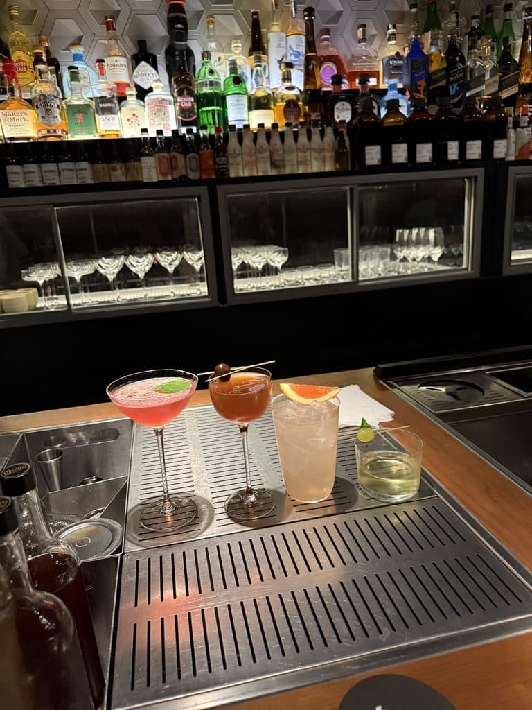 Luxury Formula 1 Travel Four cocktails on the bar at Tan Tan in São Paulo, with bottles and glassware behind them.