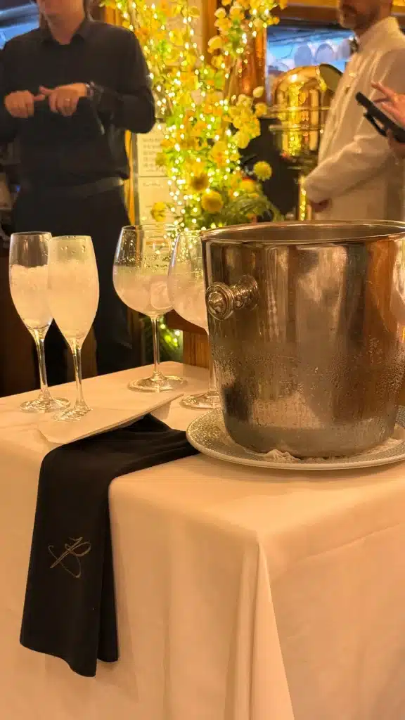FROM SUPERCARS TO SUITCASES A silver ice bucket and sparkling-wine glasses on a white-clothed table at Botafumeiro.