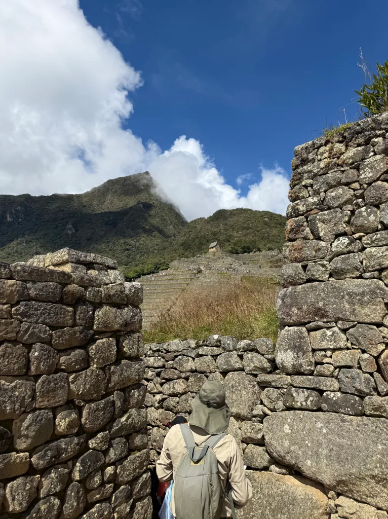 Visitor walking through a narrow stone passageway at Machu Picchu in Peru