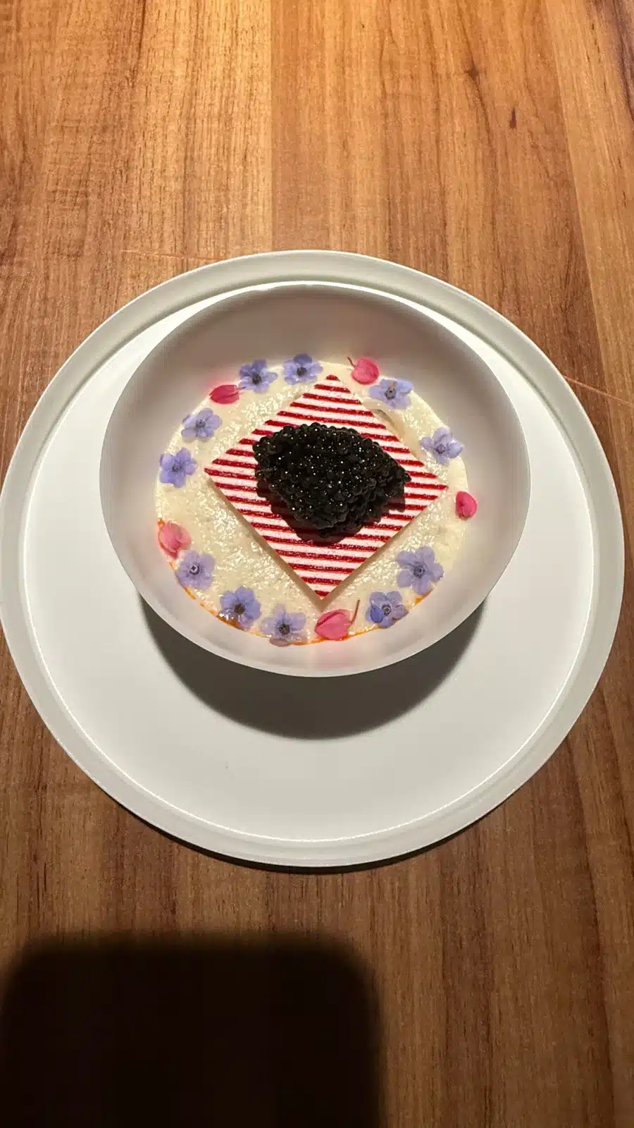 Caviar on a red-and-white striped centerpiece surrounded by colorful details at Evvai in São Paulo.