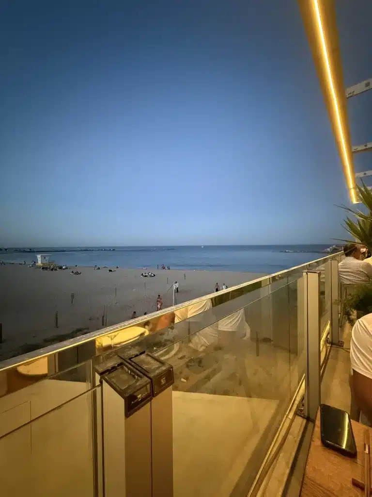 Travel Research The beach and calm sea seen from the terrace at Kresala in Barcelona at dusk.
