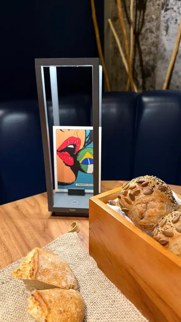Bread selection beside a wooden serving box at Evvai in São Paulo