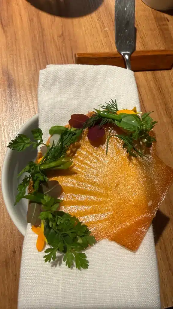 Golden scallop crisp with greens at Evvai in São Paulo.