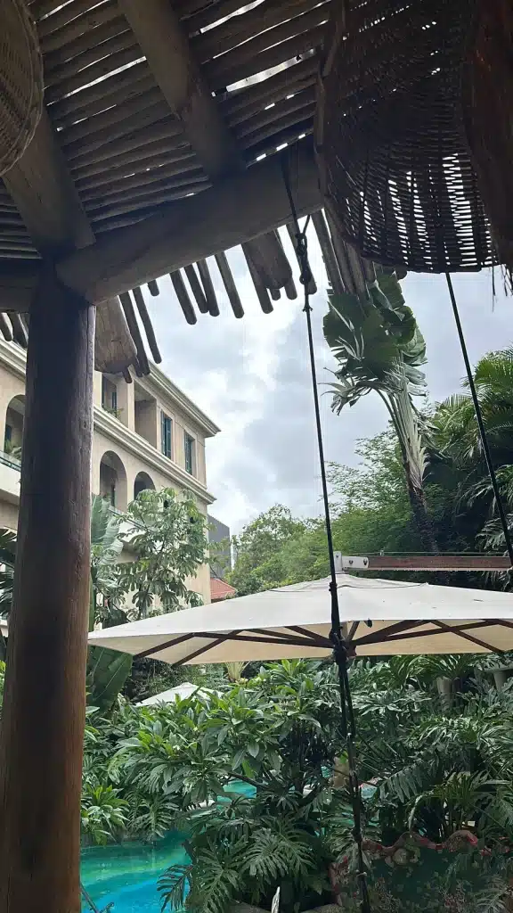 São Paulo Travel Story:  A shaded terrace overlooking tropical plants and a turquoise pool at Rosewood São Paulo.