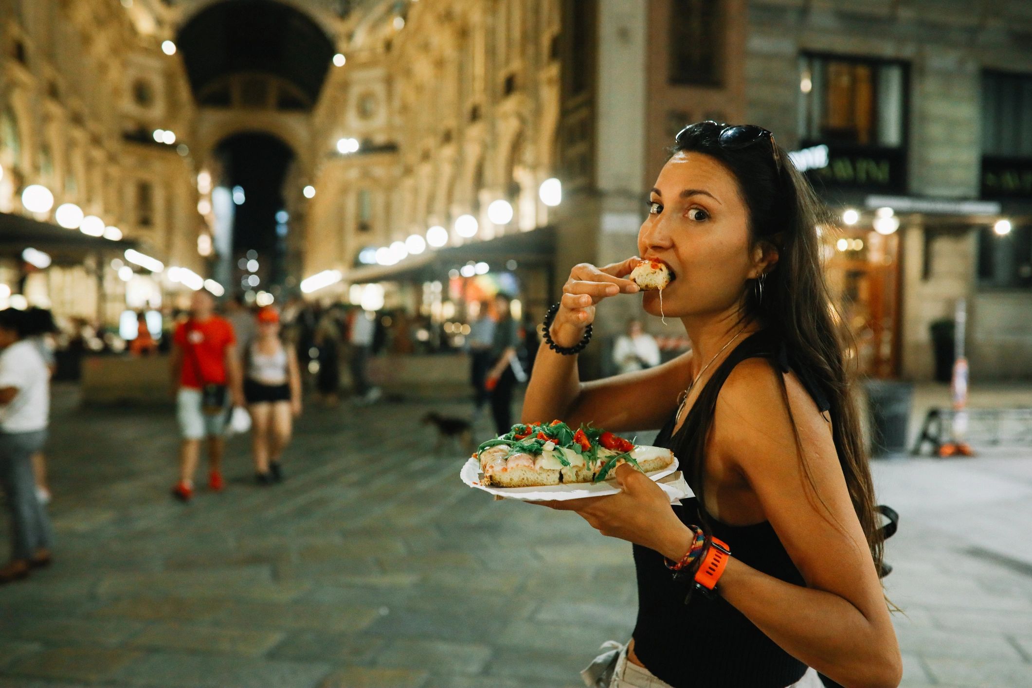 Traveler enjoying pizza on a city street in Milan
