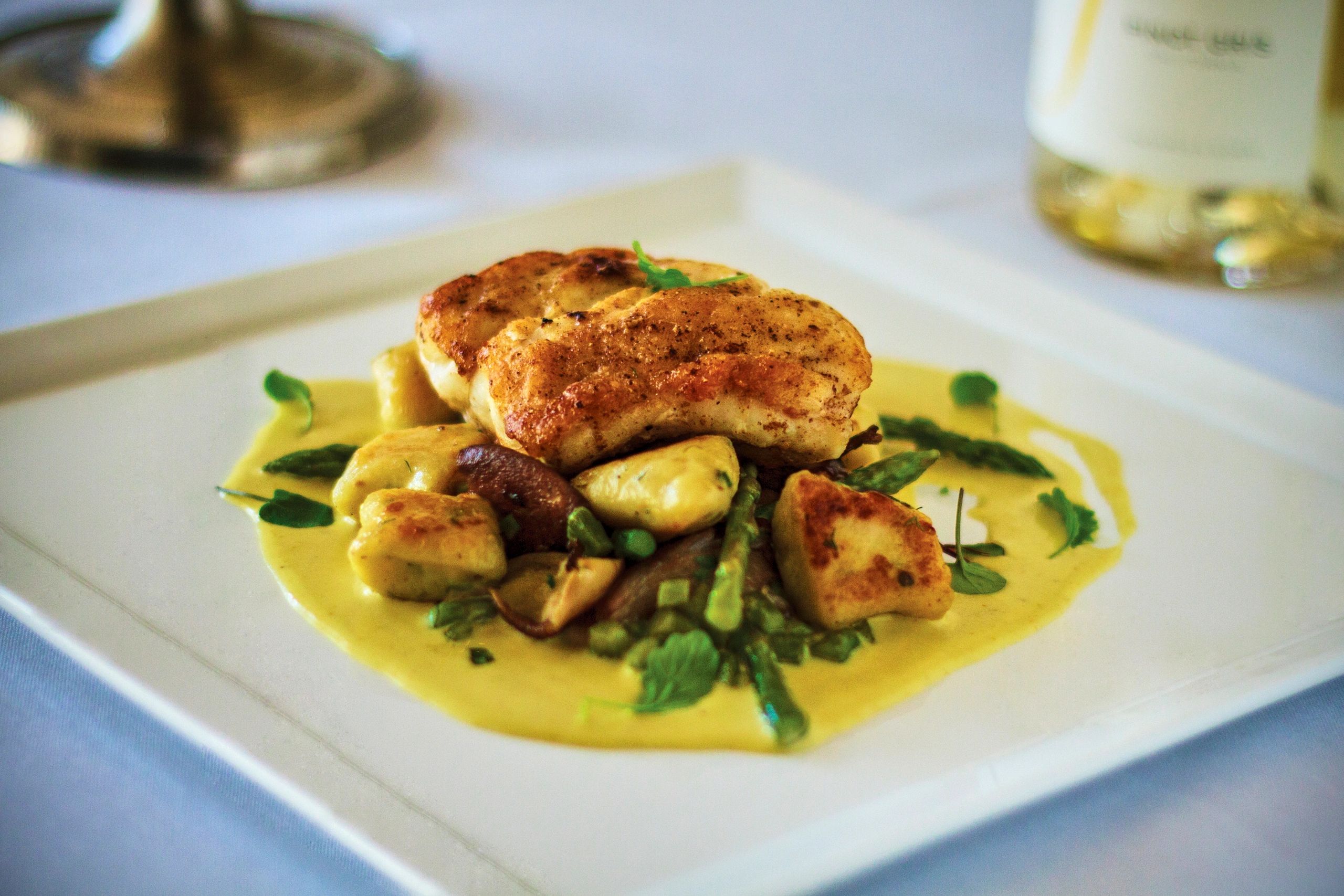 Seared halibut plated with vegetables