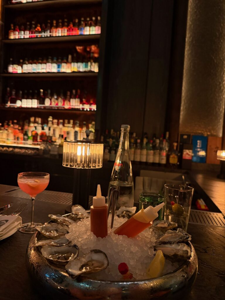 Fresh East Coast and West Coast oysters served over crushed ice with a Cosmopolitan at Bar Chimera in New York City.