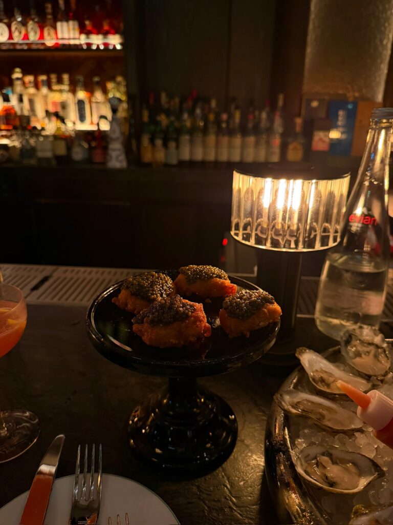 Golden Nuggets topped with caviar served at the Whiskey Bar alongside fresh oysters at Bar Chimera in New York City.