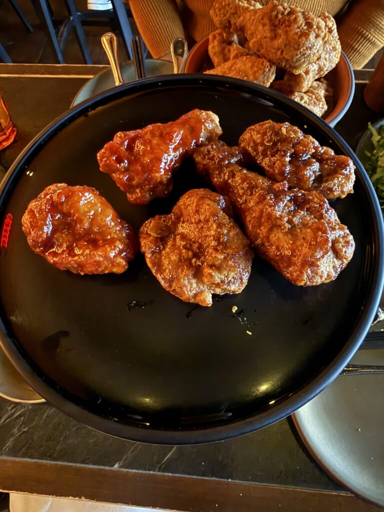 COQODAQ's signature Korean fried chicken served with multiple seasoning options in New York City.