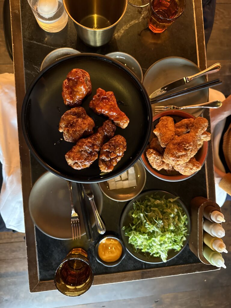 COQODAQ's signature Korean fried chicken served with four house-made sauces and fresh herbs in New York City.