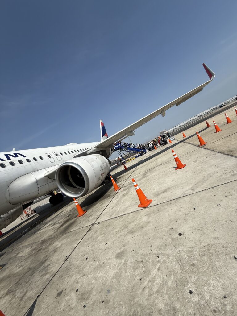Travel Research Process LATAM Airlines aircraft on the airport tarmac during passenger boarding, marking the beginning of a carefully planned travel experience.