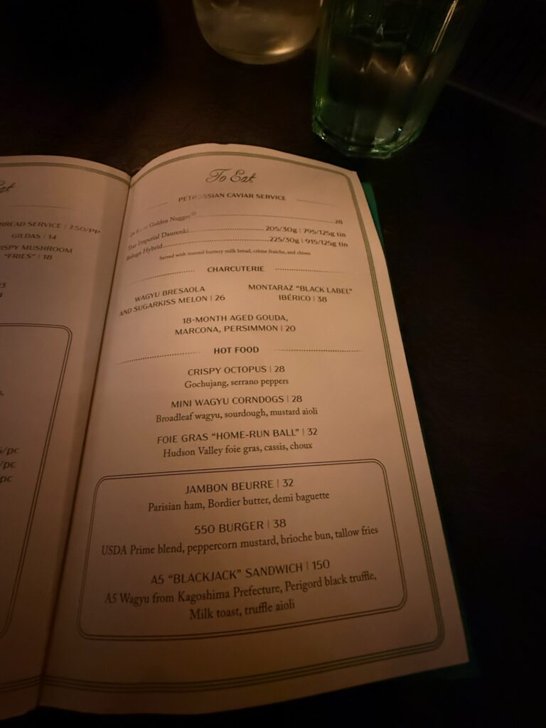 The food menu at Bar Chimera inside 550 Madison in New York City, featuring the A5 Blackjack Sandwich, caviar service, charcuterie, and signature dishes.