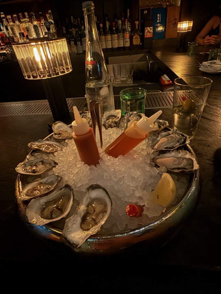 Fresh oysters served over crushed ice with a cocktail at the Whiskey Bar inside Bar Chimera in New York City.