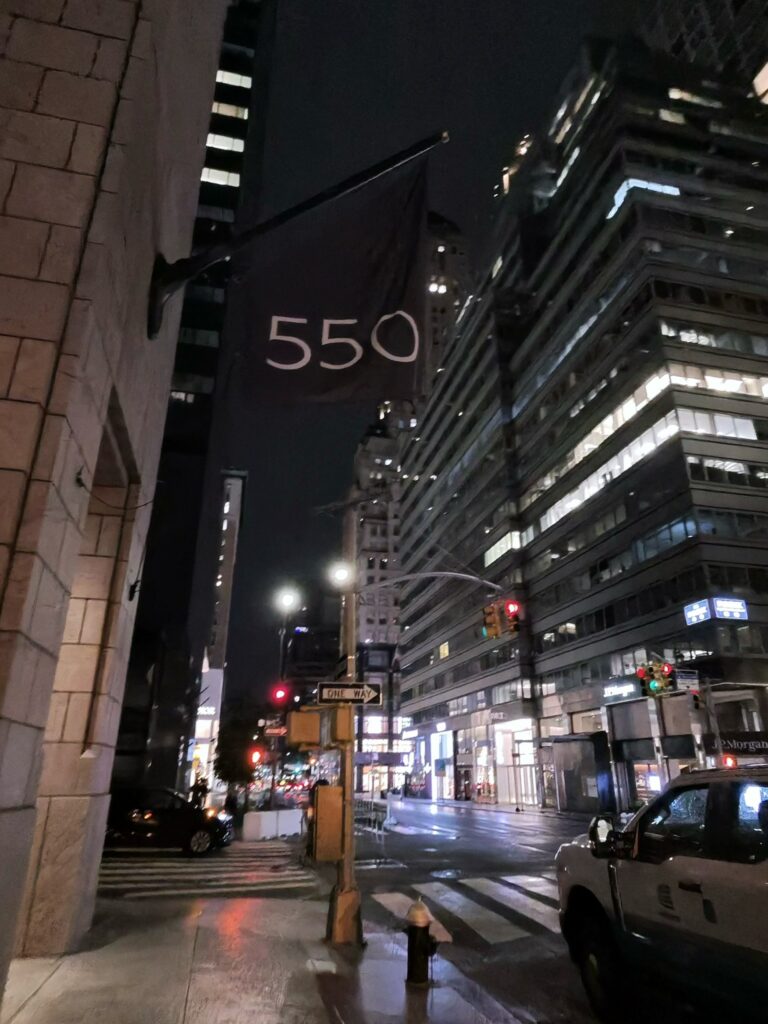The exterior of 550 Madison, home to Bar Chimera, illuminated at night in Midtown Manhattan, New York City.