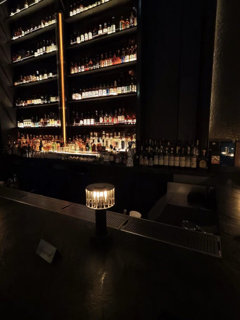 The Whiskey Bar at Bar Chimera inside 550 Madison in New York City, featuring a floor-to-ceiling collection of premium whiskey and spirits.