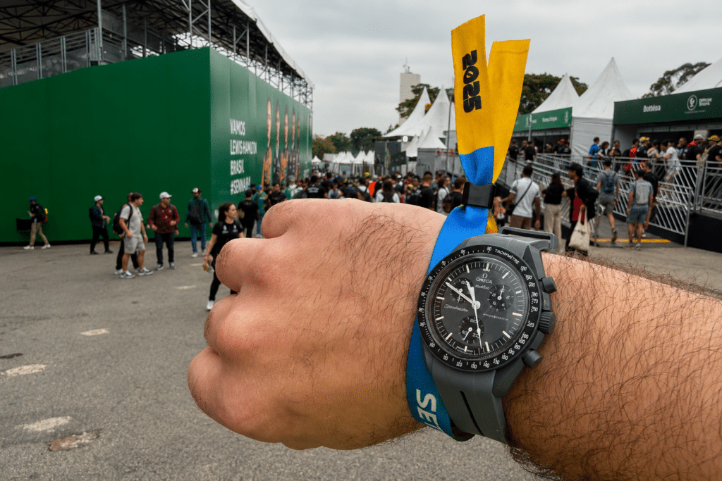 Wrist wearing a MoonSwatch and 2025 event band at the São Paulo Grand Prix in Interlagos.