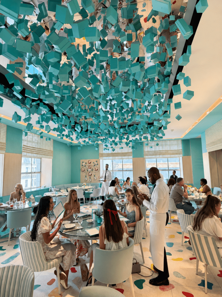 Busy Saturday breakfast service beneath the suspended Tiffany Blue Box installation at the Blue Box Café in New York City