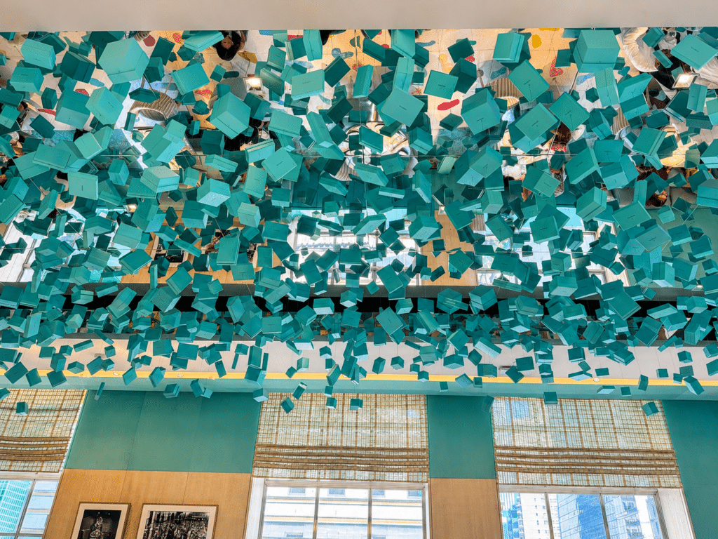 Hundreds of suspended Tiffany-blue boxes reflected across the mirrored ceiling inside the Blue Box Café in New York City