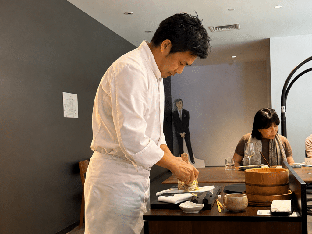 Chef Tasuku Murakami grates fresh wasabi at the Dassai Blue omakase counter.