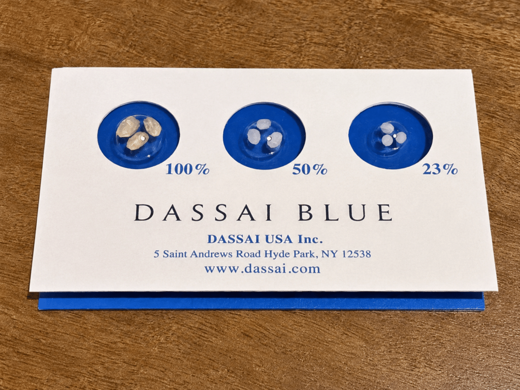 A Dassai Blue display comparing sake rice grains at 100, 50 and 23 percent of their original size.