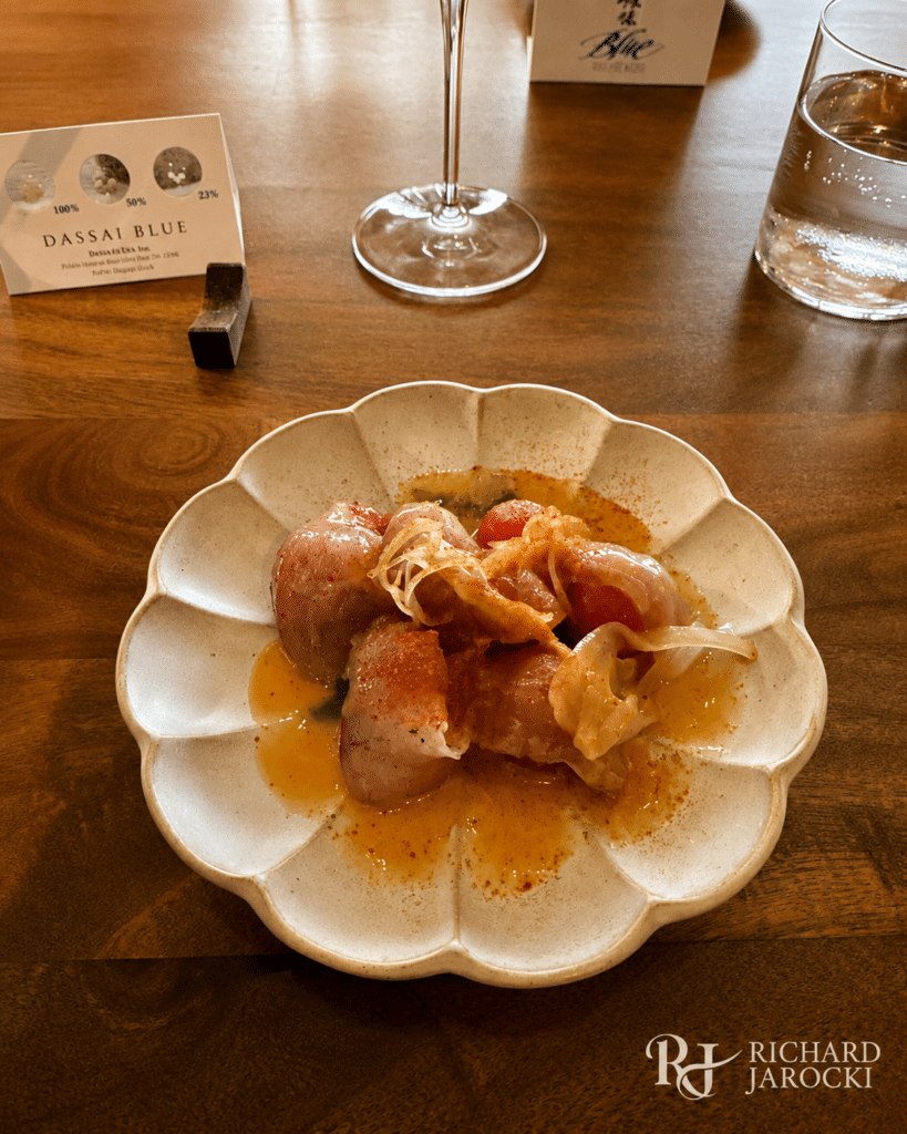 Chilled summer cabbage with tofu sauce and walnuts beside a Dassai Blue sake glass.