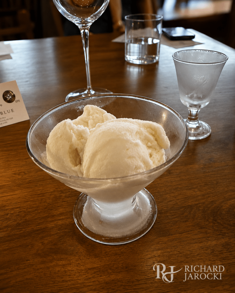 Dassai Blue sake gelato served in a glass coupe beside its Yuzu sake pairing.
