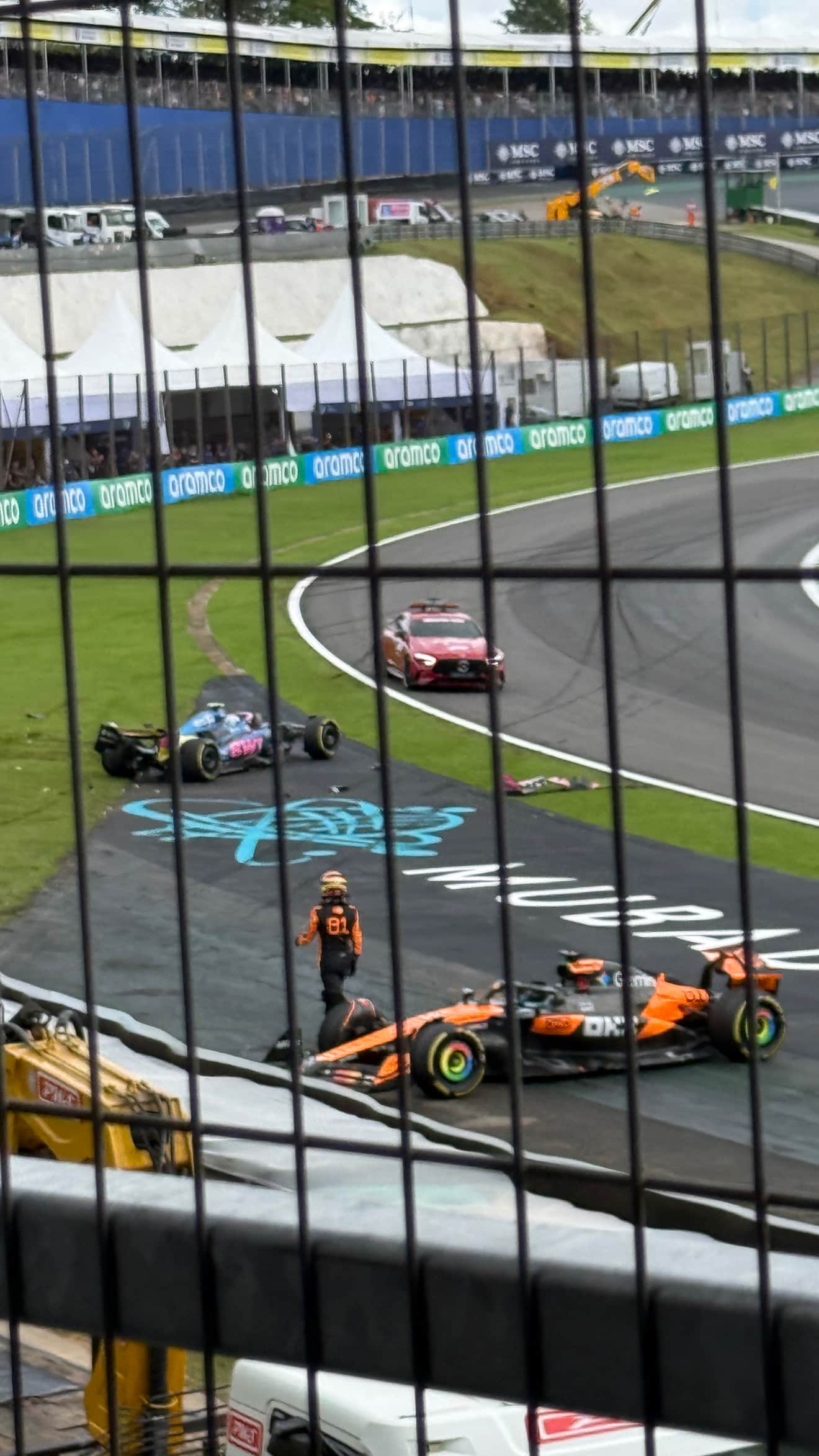 Oscar Piastri beside a stopped McLaren at Interlagos