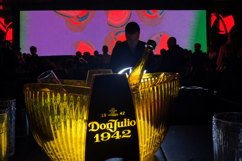 Illuminated Don Julio 1942 bottle service in front of the DJ at POSH Club’s Official Grand Prix Party