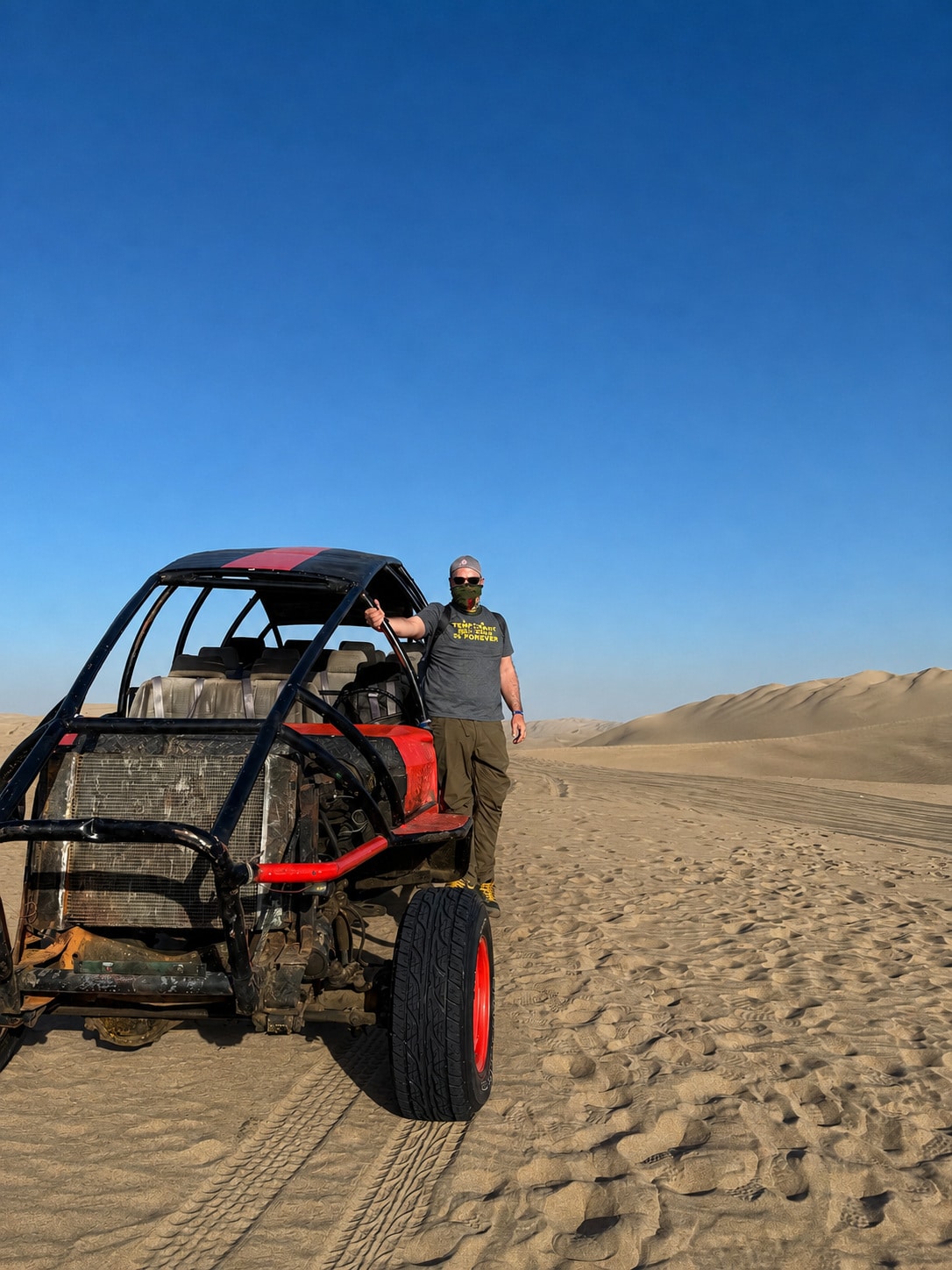 Richard Jarocki beside a dune buggy in the desert at Huacachina, Peru.
