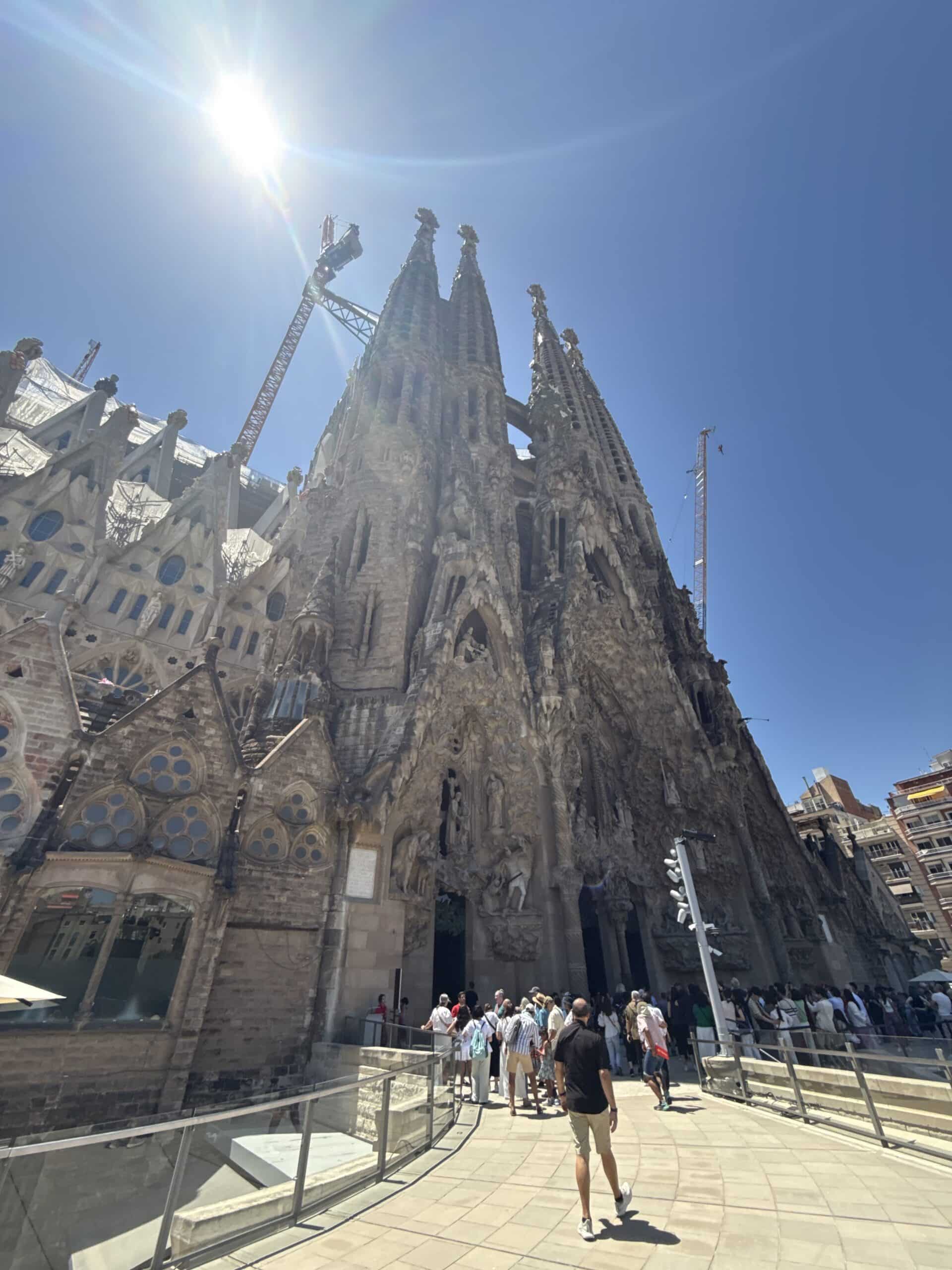 The detailed Nativity façade and towers of Sagrada Família beneath a blue Barcelona sky