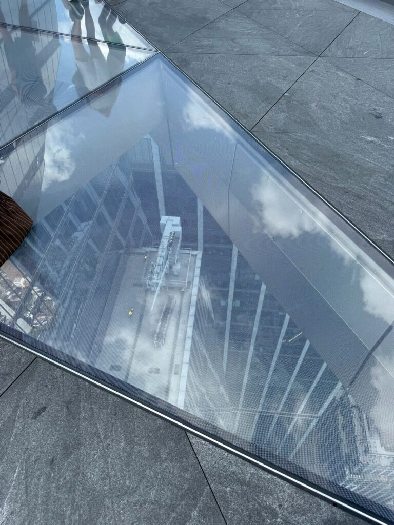 Glass floor at The Edge NYC offering a dramatic view down the side of 30 Hudson Yards