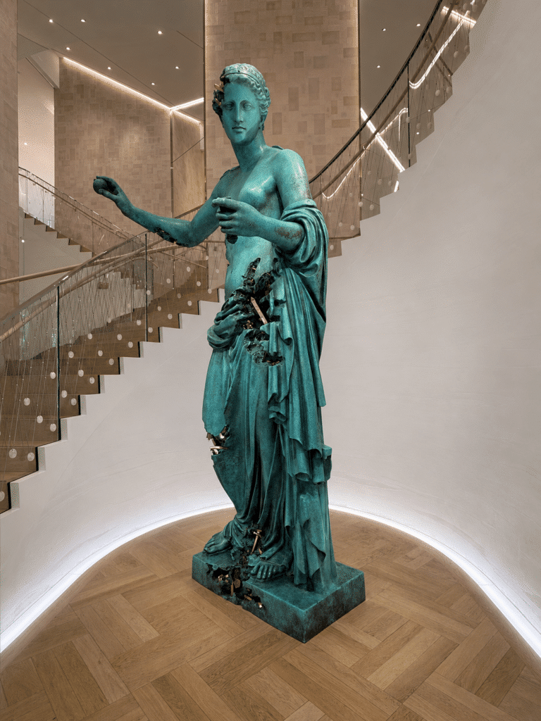 Patinated bronze sculpture framed by a curved staircase inside Tiffany & Co.’s Fifth Avenue flagship in New York City