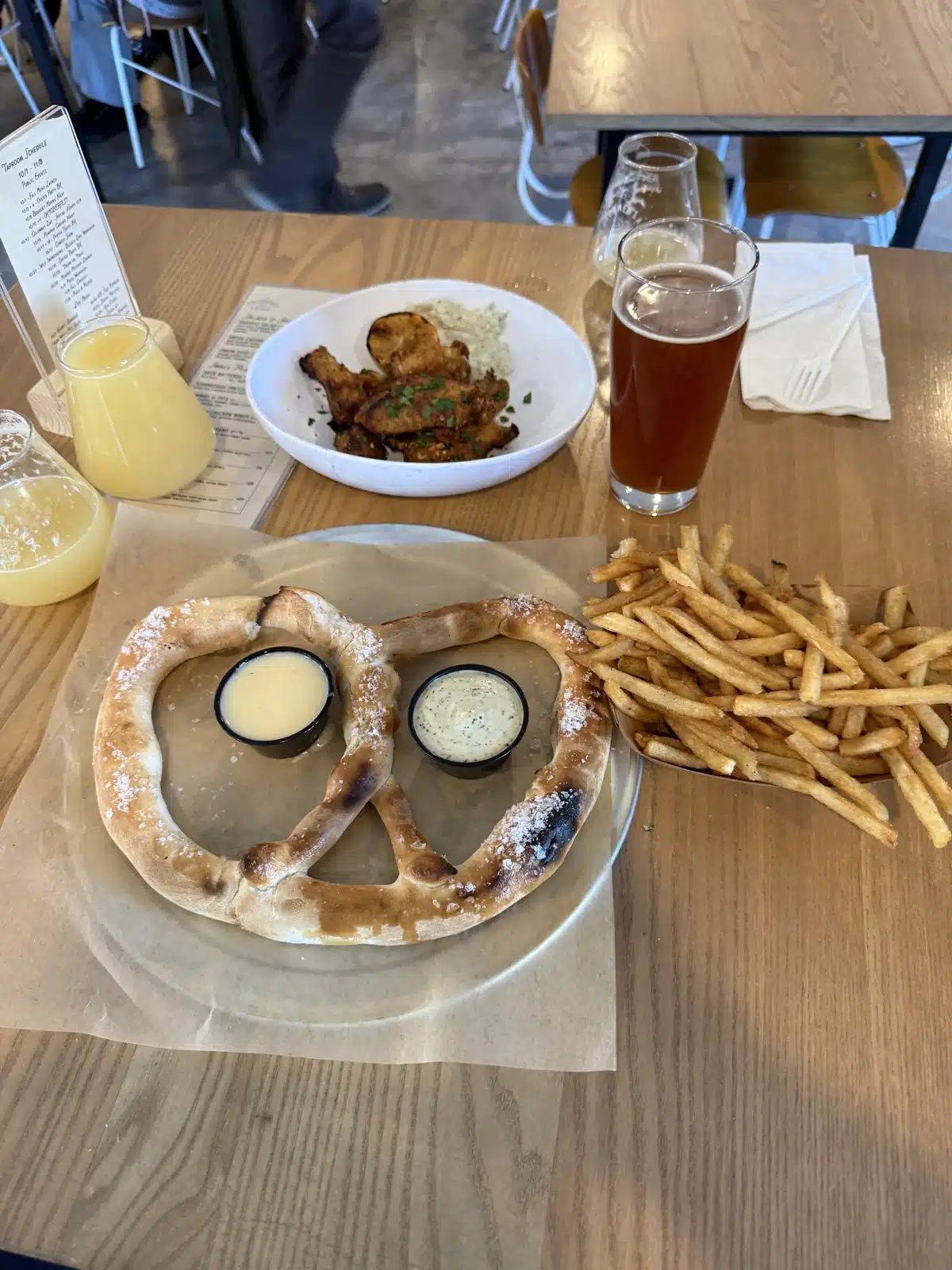 Pretzel, fries, and wings on a table during a return visit to Drowned Lands Brewery