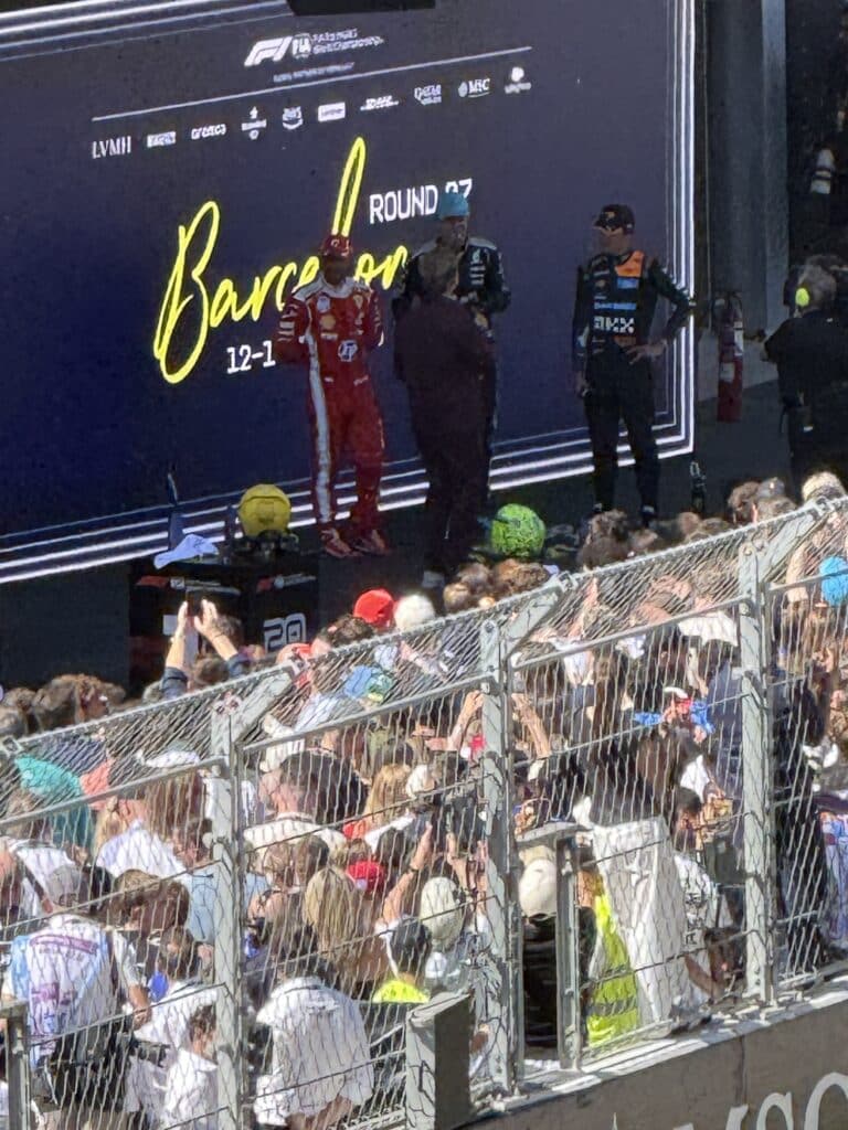 Why I Love Formula 1 Lewis Hamilton, George Russell and Lando Norris on the interview stage at the 2026 Barcelona Grand Prix.