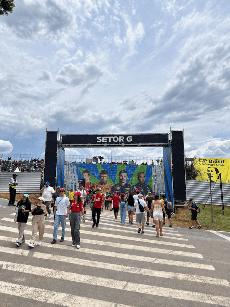 Why I Love Formula 1 Fans walking toward the Setor G entrance at Interlagos beneath a cloudy sky.