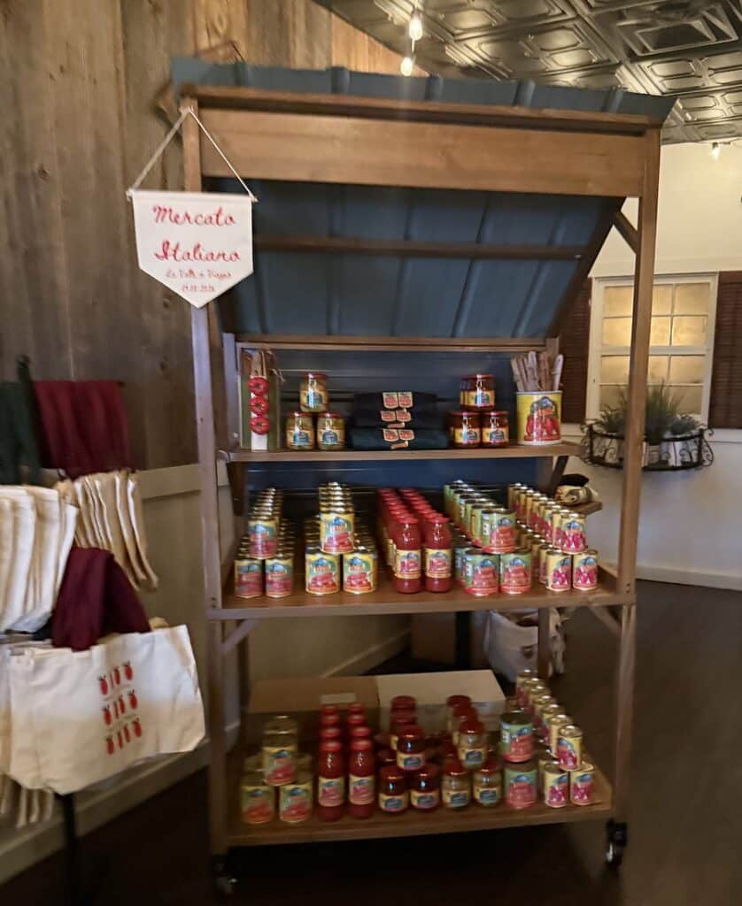 La Valle cans, jars, tomato bottles, aprons and wooden spoons arranged on a wooden market-style display at Viaggio.