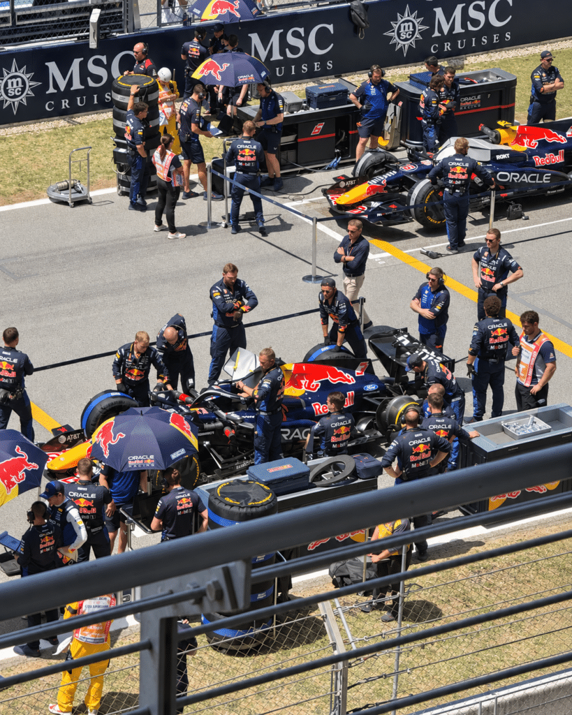 Why I Love Formula 1 Red Bull Formula 1 cars surrounded by team members on the starting grid in Barcelona.