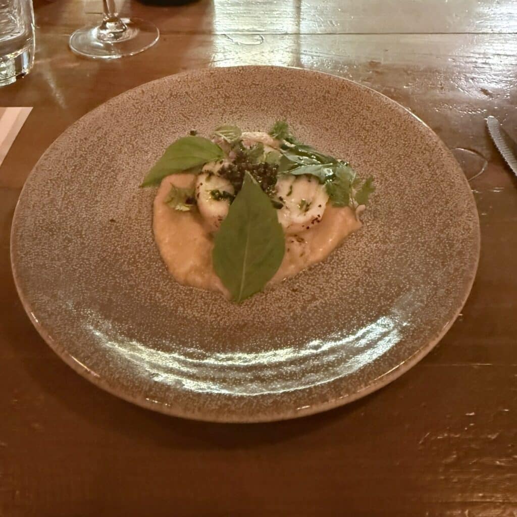 Hiramasa Mosaic topped with green leaves and caviar on a speckled plate at Viaggio.