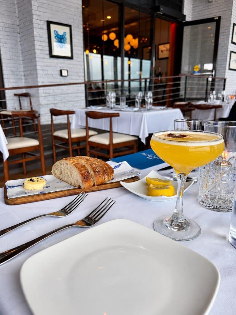 Cocktail, bread and dinner table overlooking the Hudson River at Blu Pointe