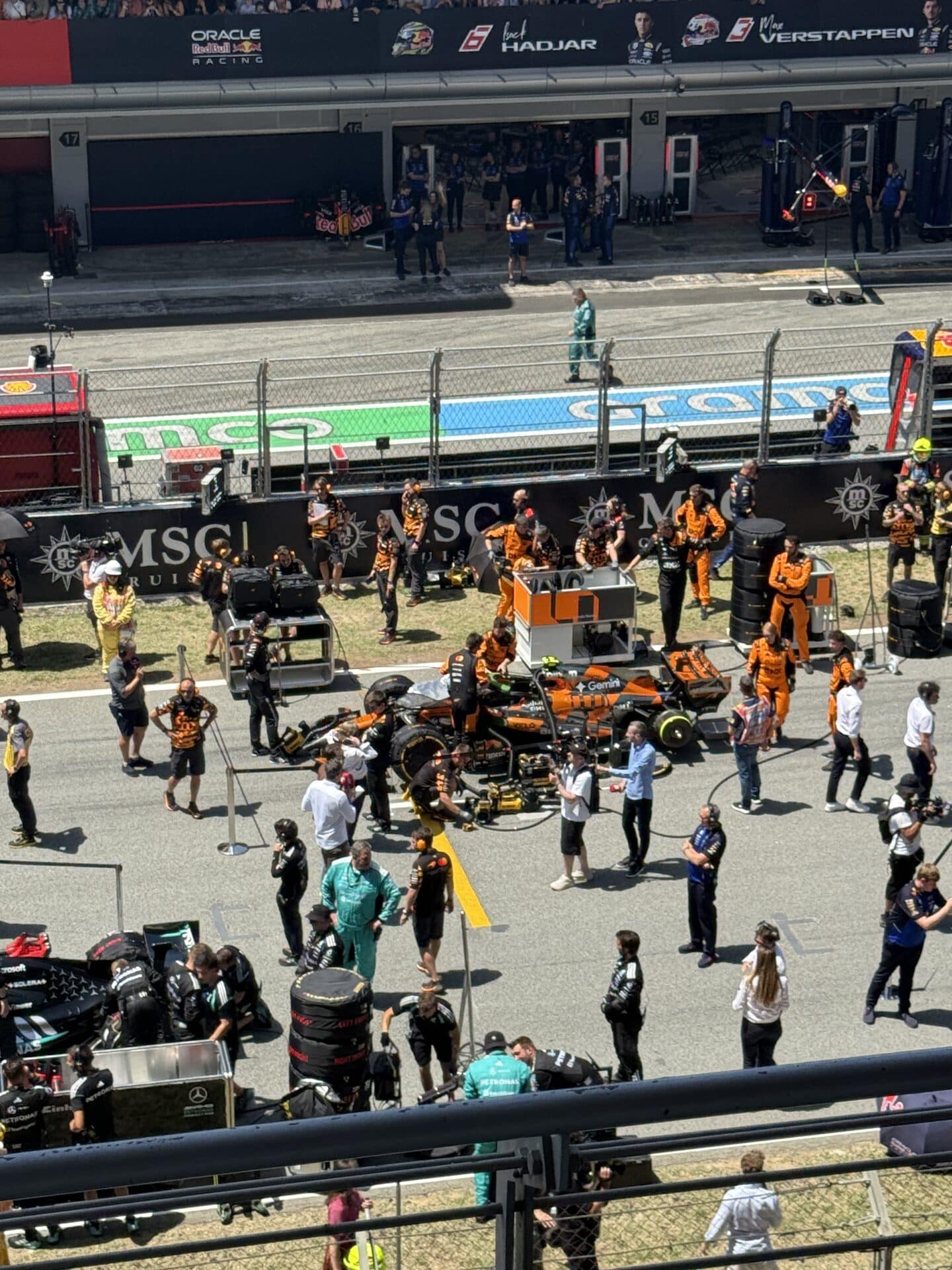 McLaren team preparing a Formula 1 car on the grid in Barcelona.